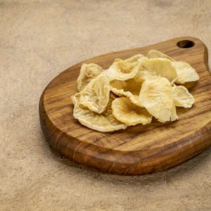 Dried slices of yacon tuber on a small wooden cutting board